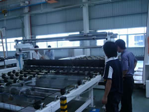Two Film Roll Supports Above Conveyor Allowing Fast Interchanging of Film Rolls